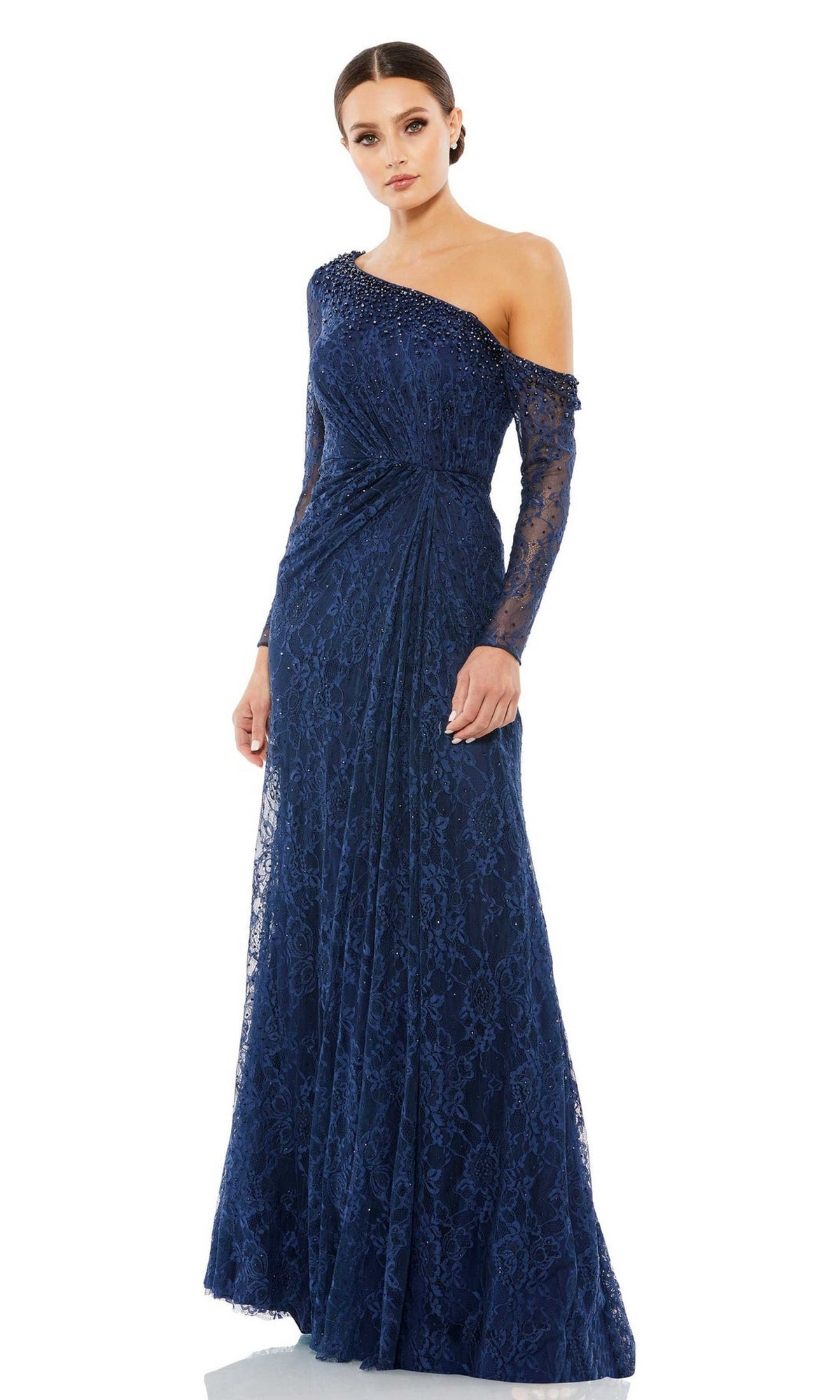 A woman wears the Long Formal Dress 67852 by Mac Duggal, a floor-length navy lace gown featuring an embellished off-the-shoulder neckline, one long sleeve, and gathered waist detailing.